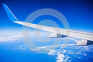 View of jet plane wing with blue sky