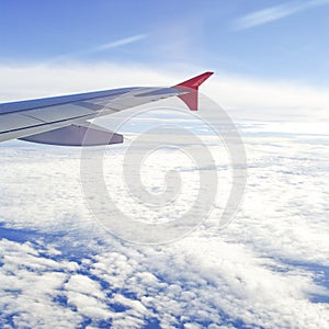 View of jet plane wing with cloud patterns