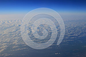 View of jet plane wing with cloud patterns