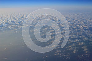 View of jet plane wing with cloud patterns