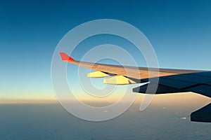 View of jet plane wing with cloud patterns