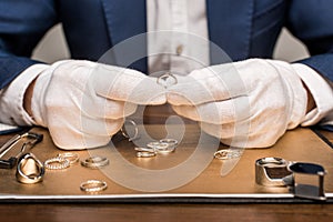 View of jewelry appraiser holding jewelry photo