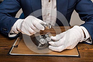 View of jewelry appraiser holding magnifying