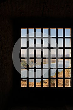 View of Juromenha castle with grid window in Alentejo landscape, in Portugal