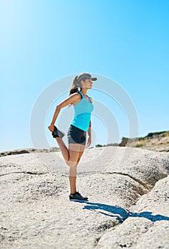 This view just inspires me. a young woman stretching while out on the beach on a sunny day.