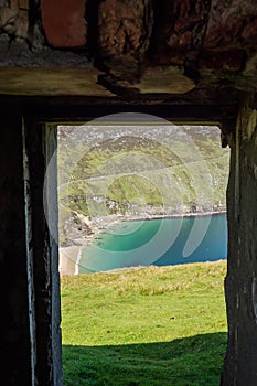 View on Keem beach from a door of an old building. Achill island, county Mayo, Ireland. Beautiful sandy beach with clear blue