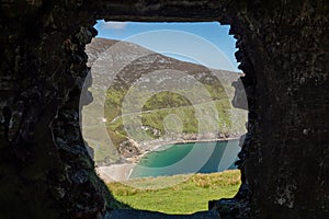 View on Keem beach from a window of an old building. Achill island, county Mayo, Ireland. Beautiful sandy beach with clear blue