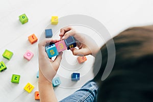 View of kid with dyslexia playing with colorful building blocks