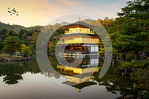 View of Kinkakuji the famous Golden Pavilion with Japanese garden and pond with dramatic evening sky in autumn season at Kyoto,