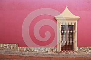 View of colorful house with pink wall and colonial window in pueblo Zimapan Hidalgo Mexico photo