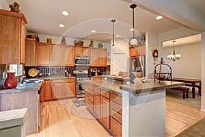 View of kitchen with hardwood storage combination, bar and pendant lights