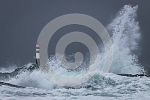 View of Kraka Lighthouse and big waves in the Atlantic Ocean, Norway photo