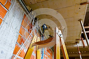 View on ladder and cable tray with bundle of cables between floors in building