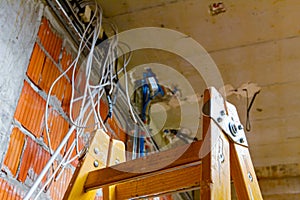 View on ladder and cable tray with bundle of cables between floors in building