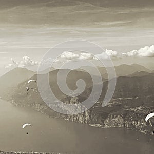 view of lake Iseo in Italy with paragliders in flight