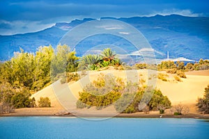 View of lake and oasis on mountain background photo