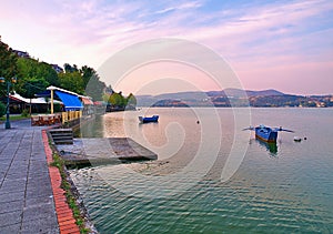 View of lake orestiada in Kastoria, Greece. Restaurants and cafes by the lake, in beautiful last light of the day