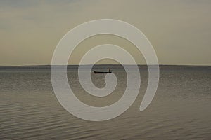 view of Lake Pleshcheyevo with a forested lake shore on the horizon and a boat