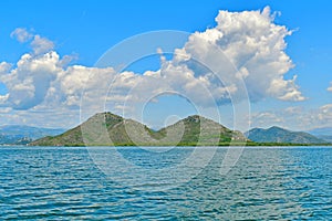 View of Lake Skadar, surrounded by bizarrely shaped mountains that resemble a woman’s breasts