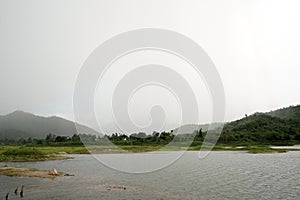 View of lake and small forest on mountain. Nimbus is on the way