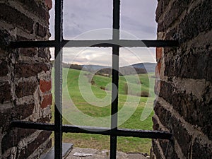 A view of the landscape through the barred window