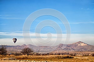 View of the landscape in the Cappadocia valley with mountains in the distance on the horizon and blue sky