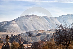 View of the landscape in the Cappadocia valley with strange yellow mountains, rocks and hills and blue sky