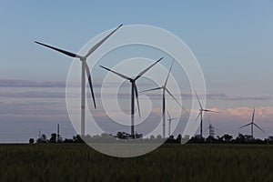 View of landscape with wind turbines in evening. Alternative energy source