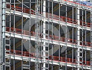 View of a large building development under construction with steel framework and girders supporting the metal floors with safety f