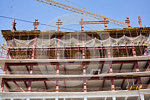 View of a large construction site with buildings under construction and multi-storey residential homes.Tower cranes in