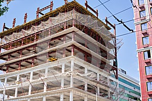 View of a large construction site with buildings under construction and multi-storey residential homes.Tower cranes in