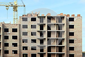 View of a large construction site with buildings under construction and multi-storey residential homes. Tower cranes in