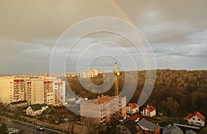 View of a large construction site with buildings under construction and multi-storey residential homes. Tower cranes in