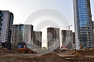 View of a large construction site with buildings under construction and multi-storey residential homes.Tower cranes in action on