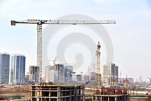 View of a large construction site. Tower cranes in action. Housing renovation concept. Crane during formworks. Construction the