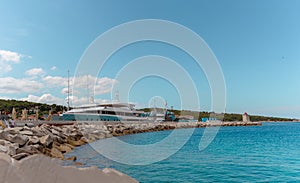 View of large yachts docked in the port of Postira, small town on the island of Brac in Croatia. Warm summer day, beautiful bright