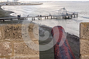 Rusty canon at Larnaca Castle pointing at Larnaca Pier, Cyprus