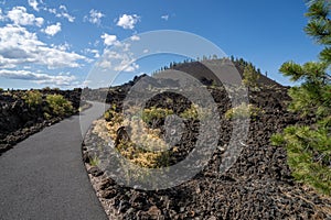 View of Lava Butte in Lava Lands at Newberry National Volcanic Monument in Central Oregon, with paved hiking trail