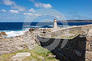 View on a lighthouse near the ocean with blue skies and white clouds