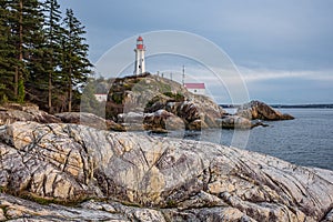 View of a Lighthouse on a rocky coast during a cloudy day, historic landmark Point Atkinson Lighthouse in West Vancouver