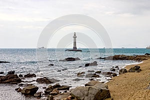 View of the lighthouse in the sea near the rocky shore. End of the World Park, Sanya, China