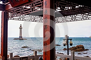 View of the lighthouse in the sea near the rocky shore. Heavenly Grottoes Park, Sanya, China