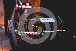 View of lighting technician operator working on mixing console workplace during live event concert on stage show broadcast, light