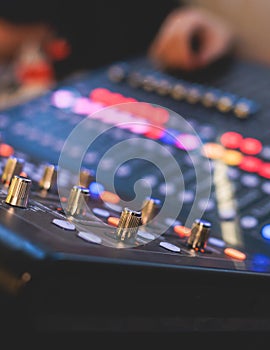 View of lighting technician operator working on mixing console workplace during live event concert on stage show broadcast, light