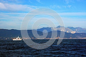 Liguria: View of Ligurian coastline with mountains sea sky boat and clouds