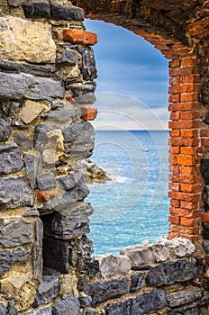 View of Ligurian sea water through brick stone medieval wall window in Lord Byron Parque Natural of Portovenere photo