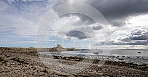 View of Lindisfarne Castle from coastal walkway on Holy Island, Northumberland, UK