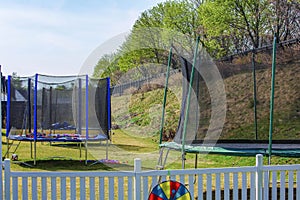 View of line of trampolines with saftey net mounted on backyards. Activity concept
