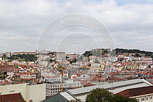 View of the Lisbon from the viewpoint Miradouro de Sao Pedro de Alcantara. Sightseeing In Portugal. Orange roofs of the old town