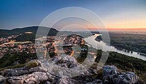 View of Lit Small City with River from the Hill at Sunset